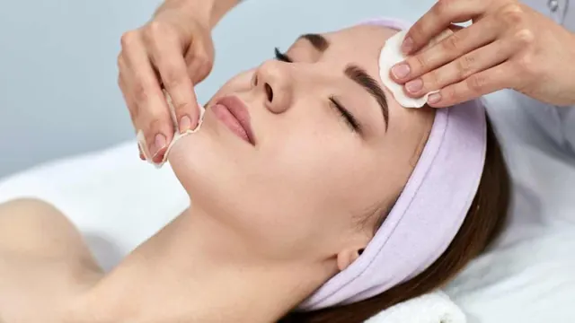 Mulher relaxada recebendo limpeza de pele com algodão