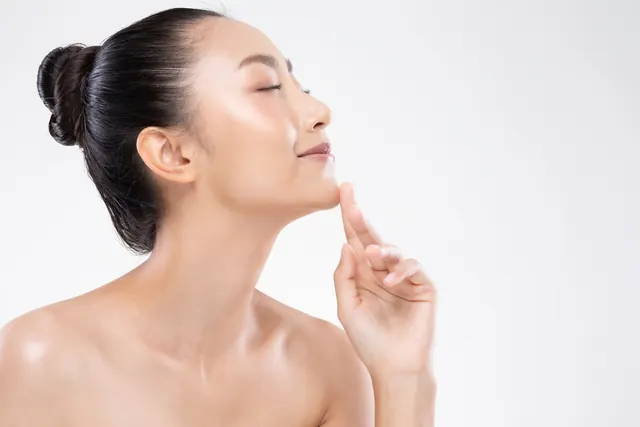 Mulher de perfil tocando o queixo, com contorno facial definido