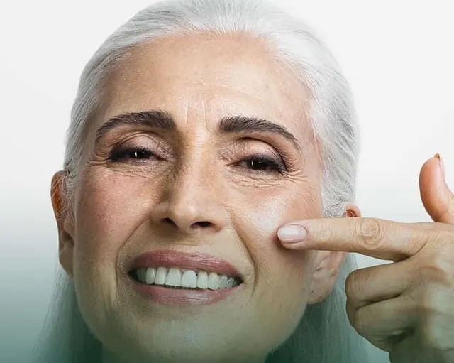 Mulher madura sorrindo e tocando a maçã do rosto